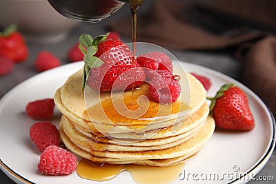 Tasty pancakes with fresh berries and honey on plate, closeup Stock Photo