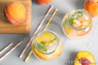 Tasty peach cocktail in glass jars on table. Stock Photo