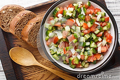 Tasty Pipirrana is a simple Spanish salad from Andalusia with tomatoes, cucumbers, bell peppers and onion closeup on the plate. Stock Photo