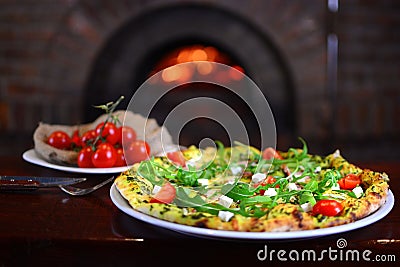 Tasty pizza in a traditional italian restaurant with a fire stone stove. Stock Photo