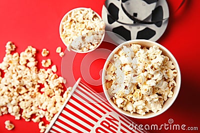 Tasty popcorn and film reel on color background, top view. Stock Photo