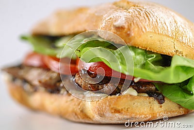 Tasty pork steak sandwich in a ciabatta with tomatos, lettuce Stock Photo