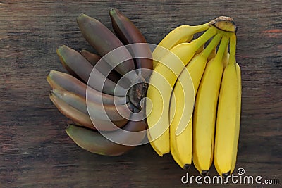 Tasty purple and yellow bananas on wooden table, flat lay Stock Photo