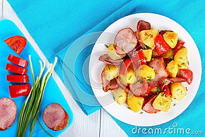 Tasty roasted potato wedges with sausages Stock Photo