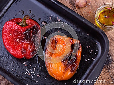 Tasty roasted red and orange bell peppers in pan Stock Photo