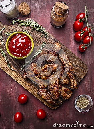 Tasty roasted ribs with spicy sauce and herbs on a cutting board on wooden rustic background top view close Stock Photo