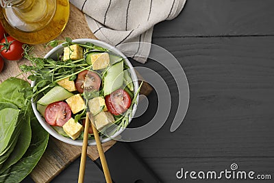 Tasty salad with tofu and vegetables near ingredients on grey wooden table, flat lay. Space for text Stock Photo