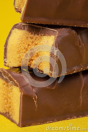 Tasty Stacked Chocolate Honeycomb Treat on yellow background Stock Photo