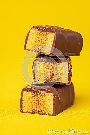 Tasty Stacked Chocolate Honeycomb Treat on yellow background Stock Photo