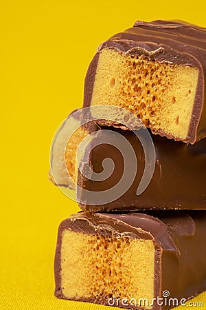 Tasty Stacked Chocolate Honeycomb Treat on yellow background Stock Photo