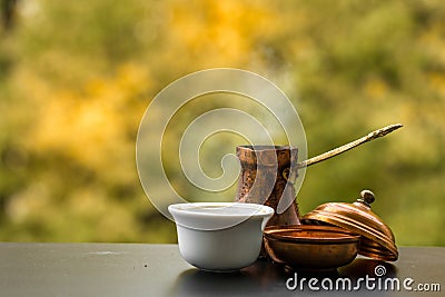Tasty steaming coffee brewed in traditional turkish coffee pot, cafe table outside Stock Photo