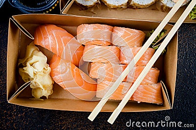 Tasty sushi rolls in disposable kraft paper boxes, sauces, chopsticks. Sushi for take away or delivery Stock Photo