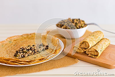 Tasty thin pancakes with fillings. Stuffed crepes with minced chicken meat mushrooms and marinated cucumber. Stock Photo