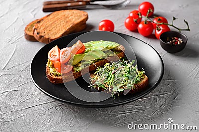 Tasty toasts with avocado on plate Stock Photo