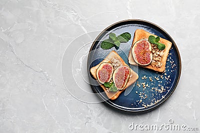 Tasty toasts with fig pieces, peanut butter and walnuts on light grey marble table, top view. Space for text Stock Photo