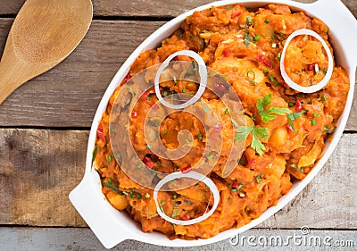 tasty yam pottage decorated with green spices and onion rings Stock Photo