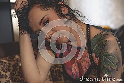 Tatoo girl on the sofa in home Stock Photo