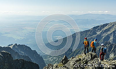 A mountain guide with a pair of clients on a mountain peak. Editorial Stock Photo