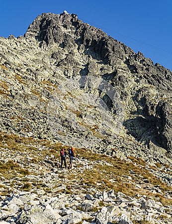 A couple of tourists reading in the guidebook the description of climbing the Lomnica peak Editorial Stock Photo