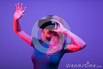 Tattoed woman wearing a virtual reality VR head set Stock Photo