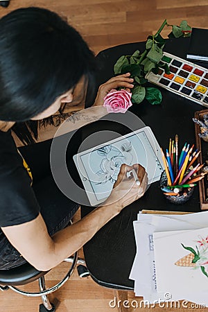 Tattoo art digital process on ipad. Tattoo artist working with Apple Pencil and drawing on iPad Pro in Procreate Editorial Stock Photo