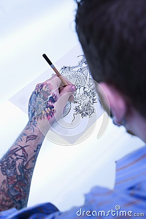 Tattoo artist drawing. Stock Photo