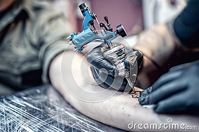 Tattoo artist drawing on client with special tools Stock Photo