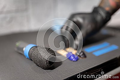 A tattoo artist is leaving some vaseline next to the machine on the work table Stock Photo