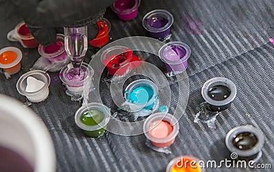 Tattoo artist mixing colors into small cup for ink Stock Photo