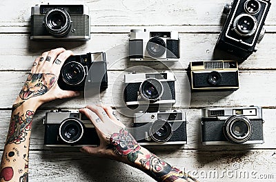 Tattooed hands with retro analog cameras Stock Photo