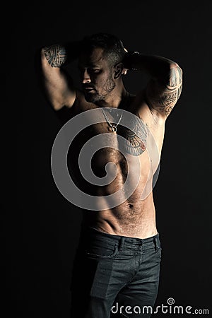 Tattooed man show sexy muscular torso. Sportsman with six pack and ab. Bodybuilder with biceps and triceps. Fashion Stock Photo