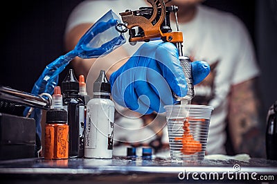 Hand of a tattooer, holding a tattoo device. Stock Photo