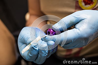 Tattooer showing process of making a tattoo, hands holding a tatoo machine Stock Photo