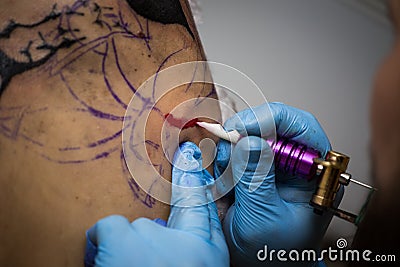 Tattooer showing process of making a tattoo, hands holding a tatoo machine Stock Photo