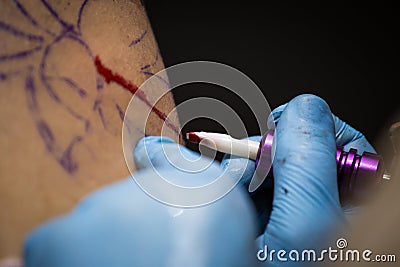 Tattooer showing process of making a tattoo, hands holding a tatoo machine Stock Photo