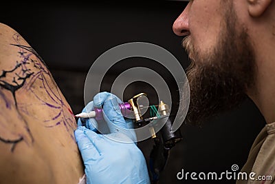 Tattooer showing process of making a tattoo, hands holding a tatoo machine Stock Photo