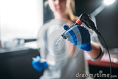 Tattooist holds tattoo machine in hand, tattooer Stock Photo