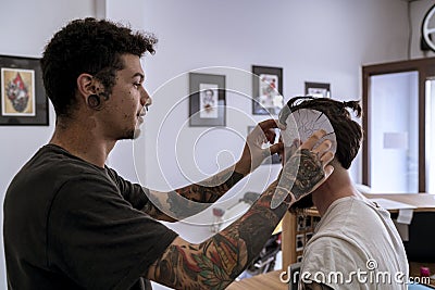 Tattooist placing the drawing on the head Stock Photo