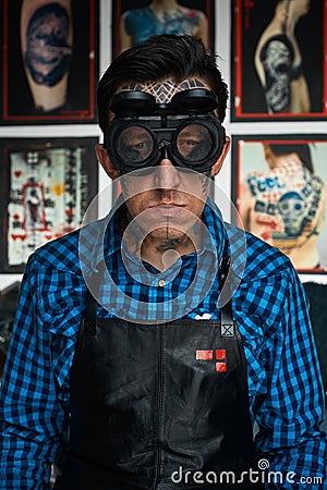 Tattooist in welder glasses and leather apron Stock Photo