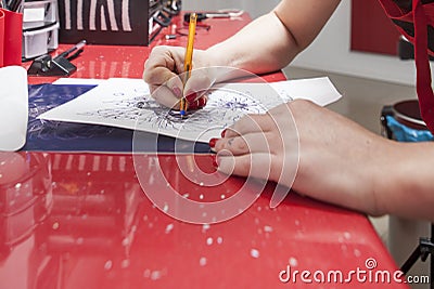 Tattooist woman tracing contours of sketch drawing Editorial Stock Photo