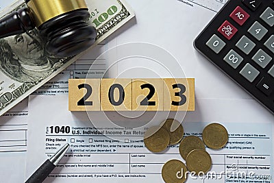 Tax concept.2023 number on wooden block.Calculator with money on 1040 tax form.The new year tax concept.Income tax return Editorial Stock Photo