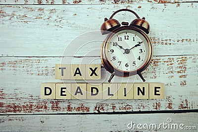 Tax Deadline with alarm clock with space copy on wooden background Stock Photo