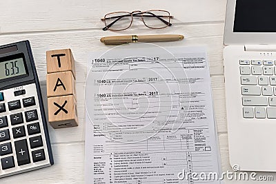 1040 tax form with dollar, laptop and wooden cubes Editorial Stock Photo