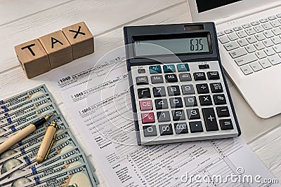 1040 tax form with dollar, laptop and wooden cubes Editorial Stock Photo