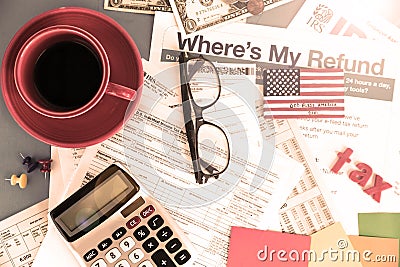 tax forms, calculator, glasses, coffee on desk. Dollars and letters TAX. View from above Editorial Stock Photo