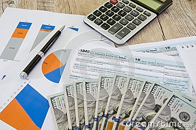 Tax forms 1040, dollars and calculator on the background of business charts. Business concept, tax concept. Editorial Stock Photo