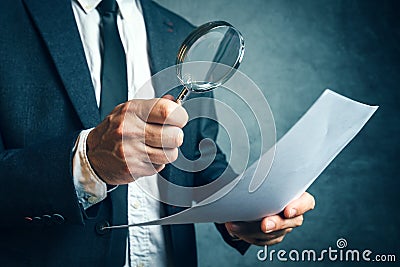 Tax inspector investigating financial documents through magnifying glass Stock Photo