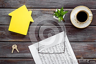 Tax for property accounting with house figure, keys, table, glasses and coffee on wooden background top view Stock Photo
