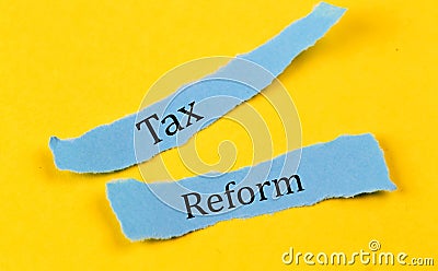 TAX REFORM text on a blue pieces of paper on yellow background, business concept Stock Photo