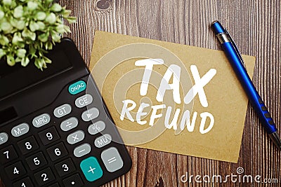 Tax Refund typography text on paper card with calculator on wooden background Stock Photo